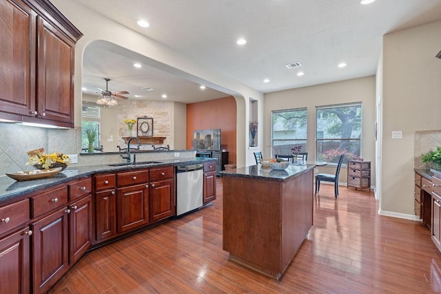10033 Lisi Anne Dr, Austin, TX 78717 - kitchen with stainless steel dishwasher, arched walkways, dark wood finished floors, plenty of natural light, and recessed lighting