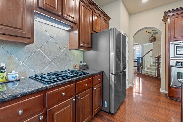 10033 Lisi Anne Dr, Austin, TX 78717 - kitchen with stainless steel appliances, dark wood-style flooring, arched walkways, decorative backsplash, and recessed lighting