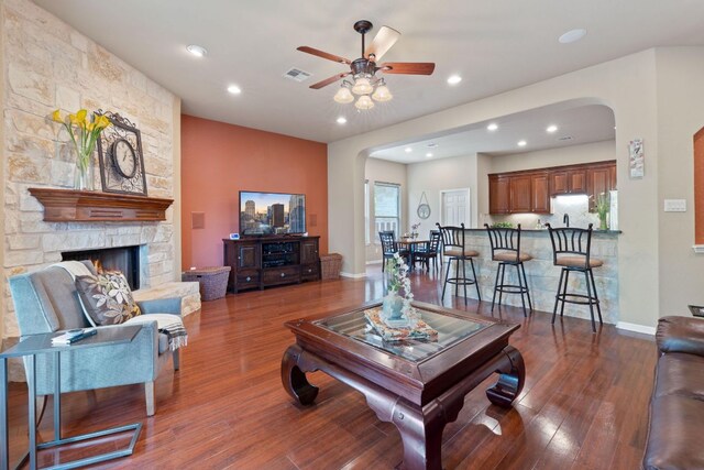 10033 Lisi Anne Dr, Austin, TX 78717 - living room featuring arched walkways, a ceiling fan, dark wood finished floors, recessed lighting, and a fireplace