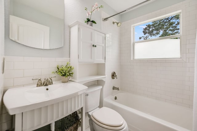 bathroom featuring toilet, shower / bathtub combination, tasteful backsplash, and a sink