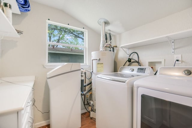 washroom featuring light wood-style flooring, water heater, washer and dryer, and laundry area