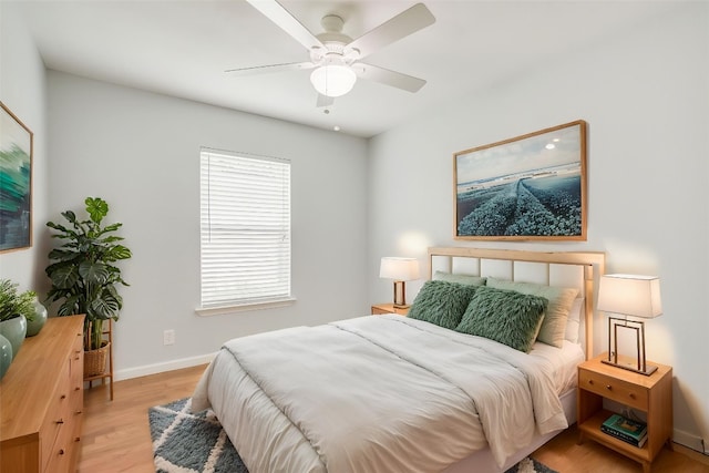 bedroom with baseboards, light wood-style floors, and ceiling fan