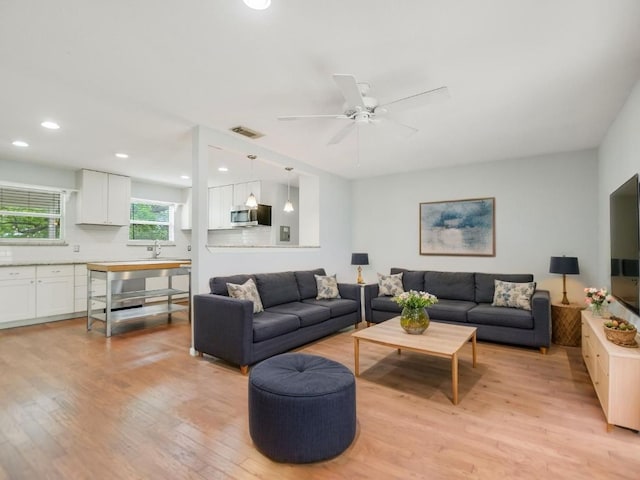 living area featuring recessed lighting, light wood-type flooring, visible vents, and a ceiling fan