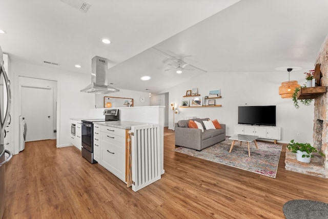 kitchen with island exhaust hood, open floor plan, visible vents, light wood-style floors, and appliances with stainless steel finishes