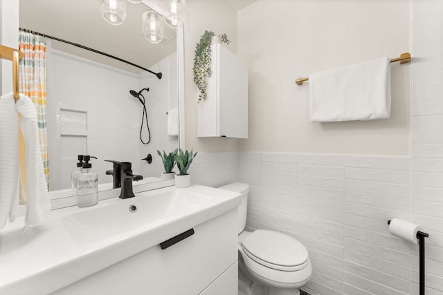 full bathroom with wainscoting, vanity, tile walls, a shower with curtain, and toilet