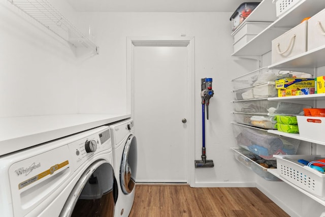 laundry area with baseboards, wood finished floors, laundry area, and independent washer and dryer