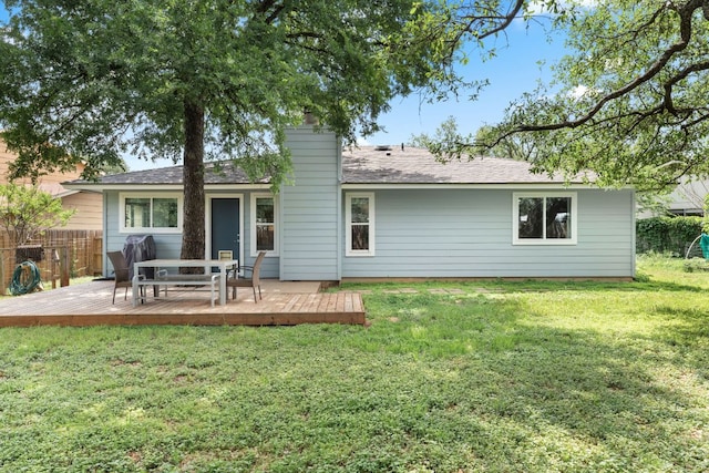 rear view of property with fence, a lawn, and a wooden deck