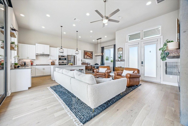 6229 Florencia Ln, Austin, TX 78724 - living room with light wood finished floors, a high ceiling, ceiling fan, and recessed lighting