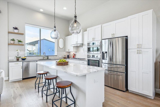 6229 Florencia Ln, Austin, TX 78724 - kitchen with appliances with stainless steel finishes, backsplash, light wood-type flooring, white cabinets, and recessed lighting