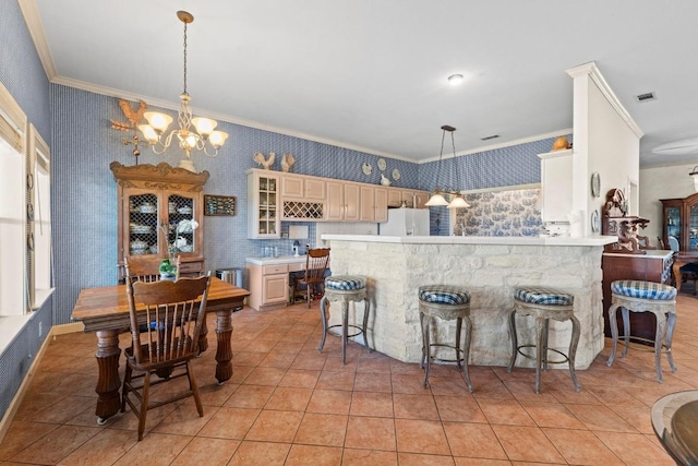 kitchen featuring ornamental molding, light tile patterned floors, glass insert cabinets, and wallpapered walls