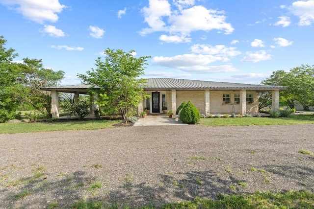 view of front of property featuring gravel driveway and metal roof