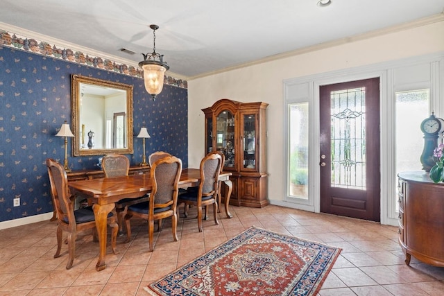 dining space featuring crown molding, baseboards, tile patterned flooring, and visible vents
