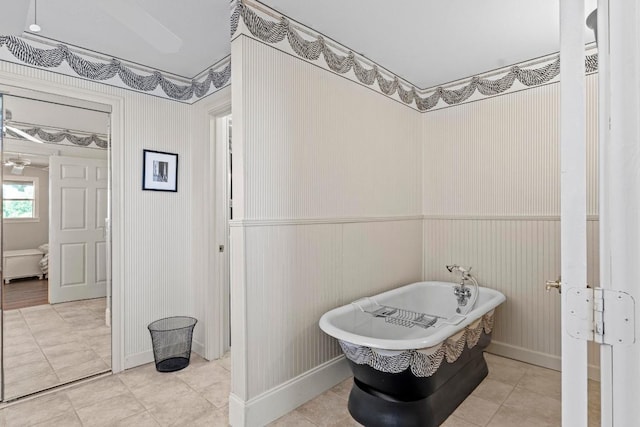 full bath with a freestanding tub, wainscoting, and tile patterned floors