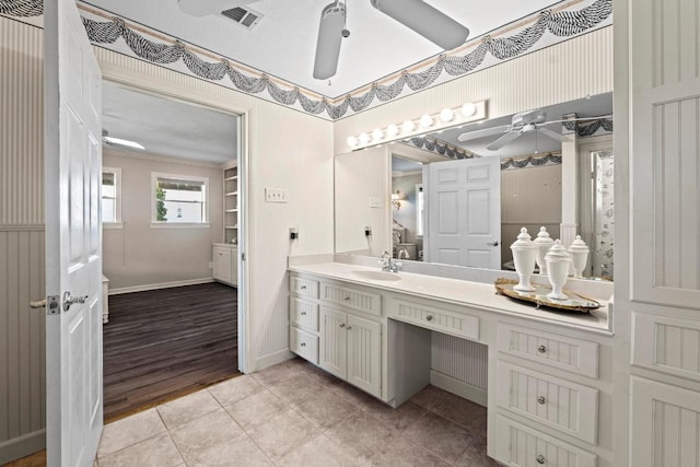 bathroom with tile patterned flooring, visible vents, vanity, baseboards, and ceiling fan