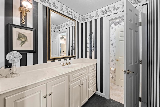 bathroom featuring wallpapered walls and vanity