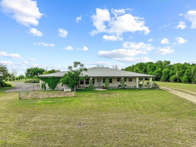 farmhouse featuring fence, metal roof, and a front yard