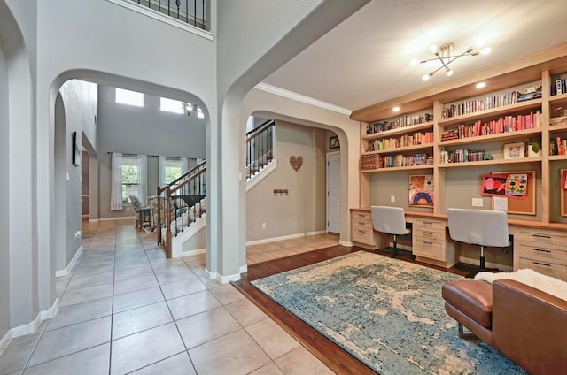 7716 Journeyville Dr, Austin, TX 78735 - office area with arched walkways, built in study area, crown molding, light tile patterned flooring, and built in features