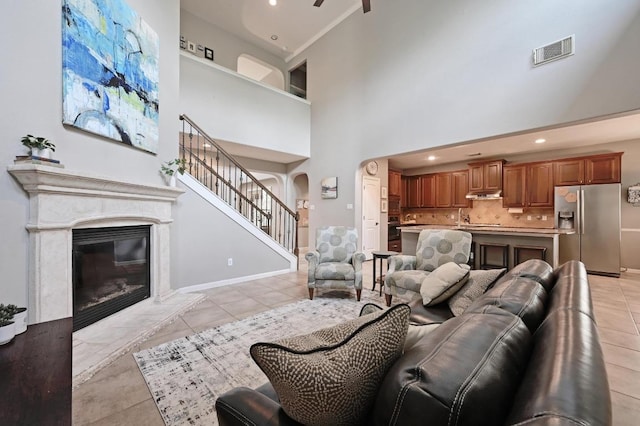7716 Journeyville Dr, Austin, TX 78735 - living room featuring a premium fireplace, stairway, a high ceiling, light tile patterned floors, and recessed lighting