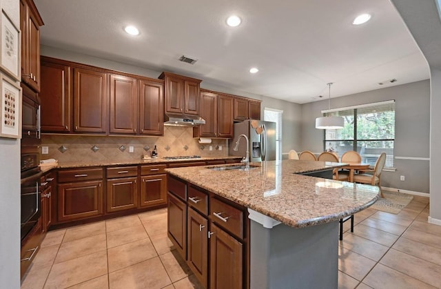 7716 Journeyville Dr, Austin, TX 78735 - kitchen featuring gas stovetop, a kitchen bar, decorative backsplash, under cabinet range hood, and light tile patterned floors