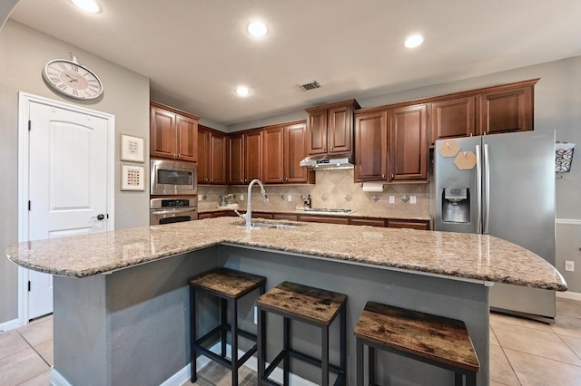 7716 Journeyville Dr, Austin, TX 78735 - kitchen with stainless steel appliances, a sink, under cabinet range hood, backsplash, and light tile patterned flooring