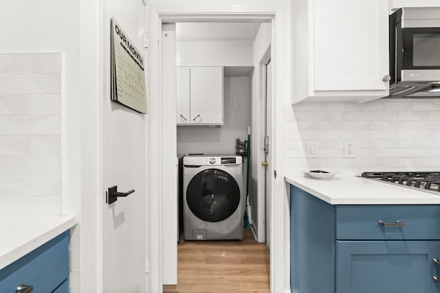 4302 Red Cloud Dr, Austin, TX 78759 - laundry room with washer / clothes dryer, cabinet space, and light wood-style floors