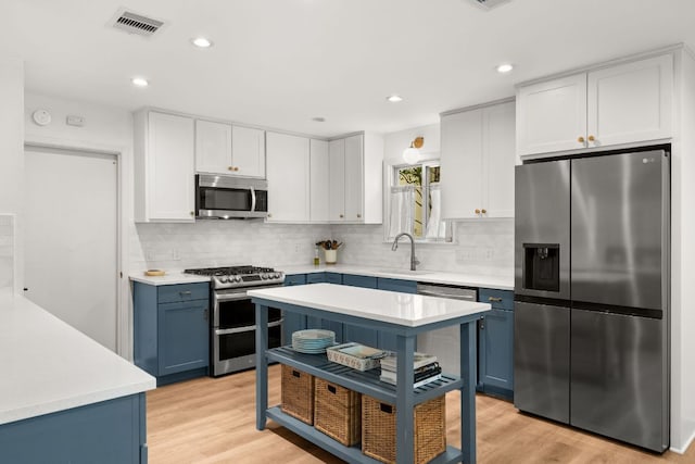 4302 Red Cloud Dr, Austin, TX 78759 - kitchen with appliances with stainless steel finishes, blue cabinets, light countertops, backsplash, and recessed lighting