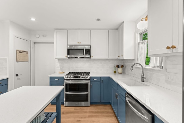 4302 Red Cloud Dr, Austin, TX 78759 - kitchen with appliances with stainless steel finishes, a sink, blue cabinetry, light countertops, and white cabinetry