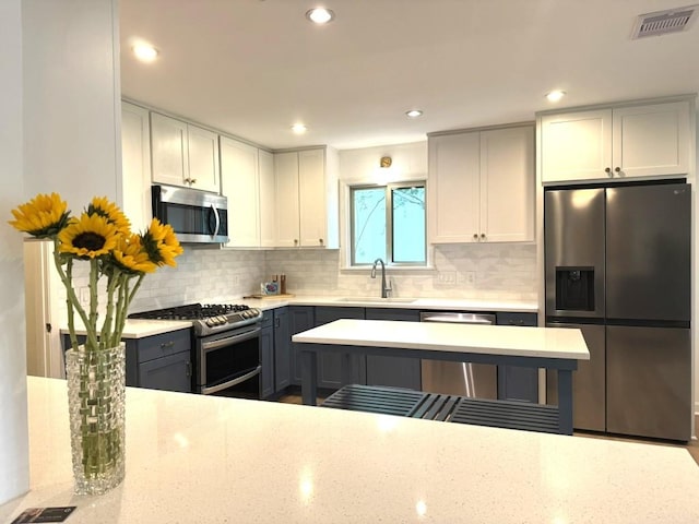 4302 Red Cloud Dr, Austin, TX 78759 - kitchen featuring appliances with stainless steel finishes, backsplash, light stone counters, recessed lighting, and gray cabinetry