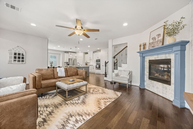 5609 Traviston Ct, Austin, TX 78738 - living room featuring a ceiling fan, a fireplace, dark wood-style flooring, stairway, and recessed lighting