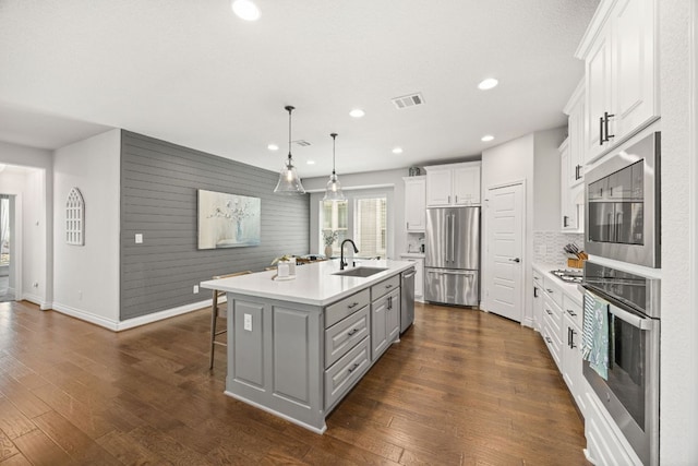 5609 Traviston Ct, Austin, TX 78738 - kitchen with stainless steel appliances, light countertops, gray cabinets, a kitchen island with sink, and recessed lighting