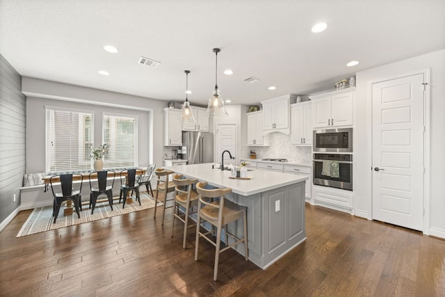 5609 Traviston Ct, Austin, TX 78738 - kitchen with appliances with stainless steel finishes, dark wood-type flooring, backsplash, light countertops, and white cabinets