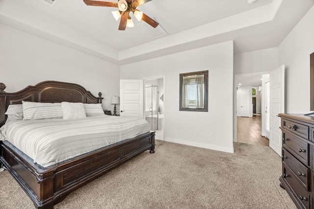 5609 Traviston Ct, Austin, TX 78738 - bedroom with light carpet, a tray ceiling, connected bathroom, and a ceiling fan
