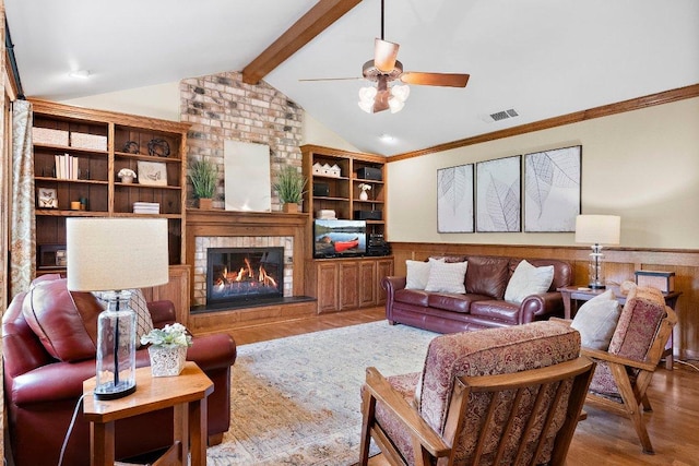 4101 Galacia Dr, Austin, TX 78759 - living room featuring wood finished floors, wainscoting, a ceiling fan, a brick fireplace, and ornamental molding