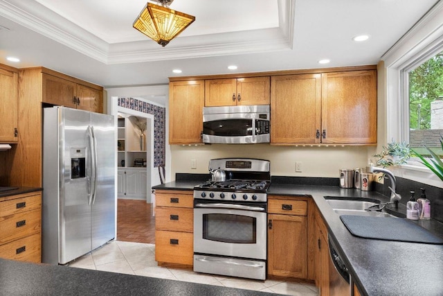 4101 Galacia Dr, Austin, TX 78759 - kitchen with appliances with stainless steel finishes, brown cabinets, a tray ceiling, dark countertops, and light tile patterned floors