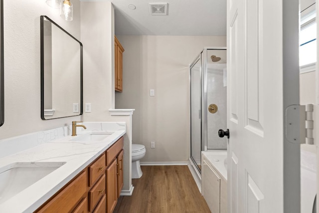 full bathroom featuring visible vents, wood finished floors, a sink, and a stall shower