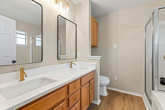 full bath with a shower stall, wood finished floors, and a sink