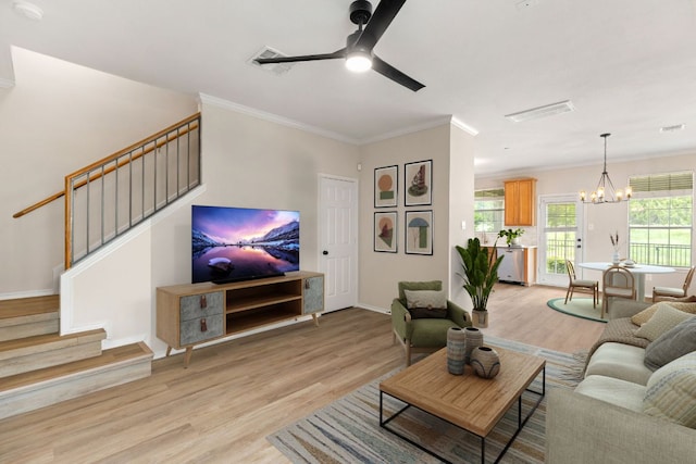 living area with light wood finished floors, crown molding, stairway, and ceiling fan with notable chandelier