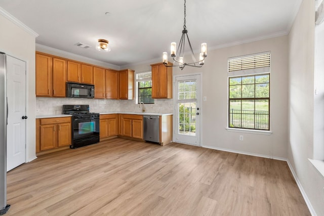 kitchen with tasteful backsplash, light wood-type flooring, a chandelier, light countertops, and black appliances