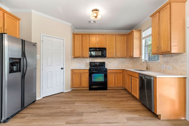 kitchen featuring light countertops, visible vents, a sink, black appliances, and light wood-style flooring