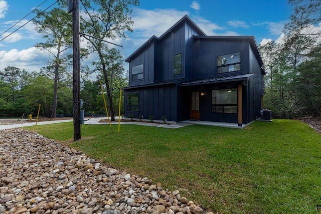 rear view of house with a lawn, cooling unit, and board and batten siding