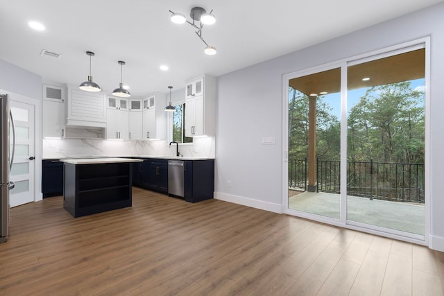 kitchen featuring light countertops, a wealth of natural light, white cabinetry, and tasteful backsplash