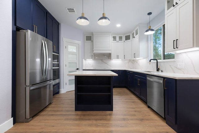 kitchen featuring a sink, tasteful backsplash, blue cabinetry, open shelves, and appliances with stainless steel finishes