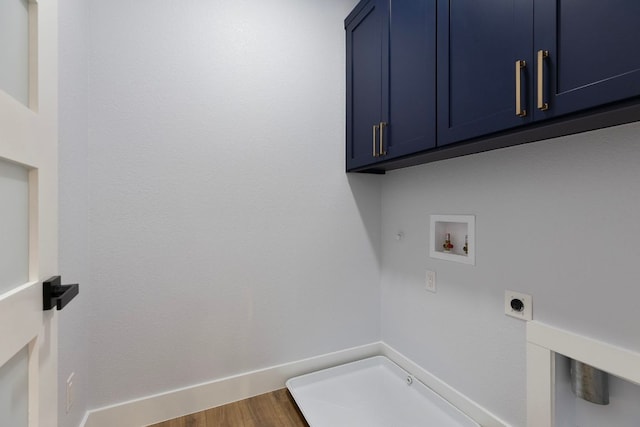 washroom with wood finished floors, hookup for an electric dryer, hookup for a gas dryer, cabinet space, and washer hookup