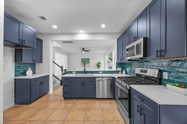 104 Summerwood Cv, San Marcos, TX 78666 - kitchen with stainless steel appliances, a sink, a peninsula, ceiling fan, and backsplash