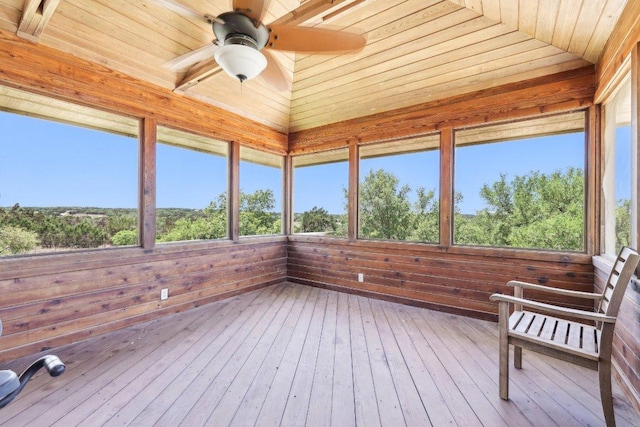 unfurnished sunroom with wood ceiling, ceiling fan, wood walls, and hardwood / wood-style floors