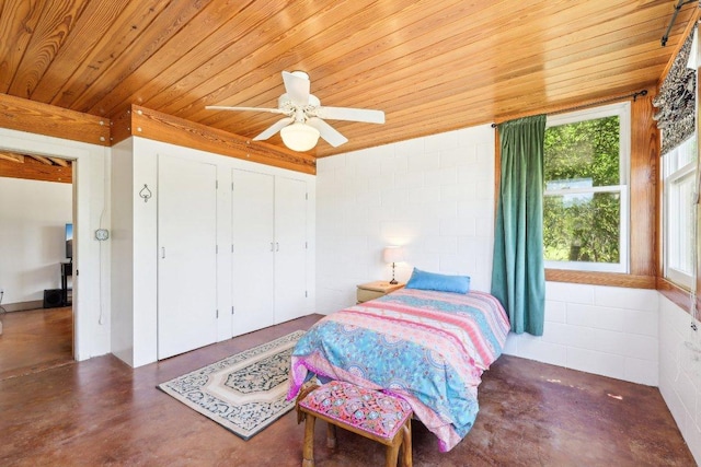 bedroom with wood ceiling, concrete block wall, finished concrete floors, and ceiling fan