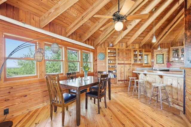 dining area featuring wood ceiling, wooden walls, light wood-type flooring, and a healthy amount of sunlight