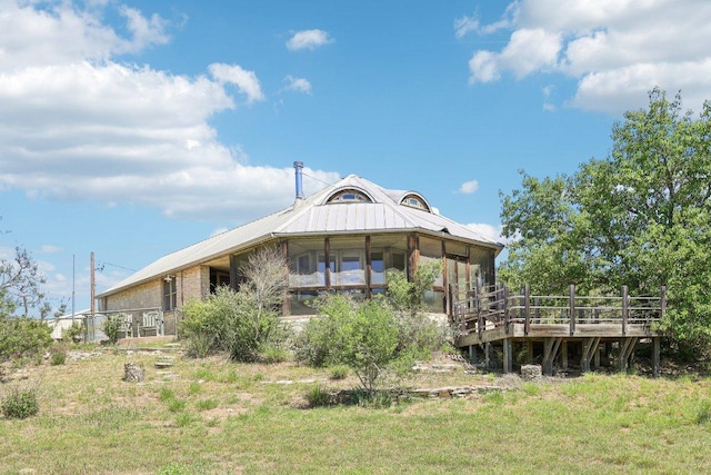 back of property with a wooden deck and a sunroom