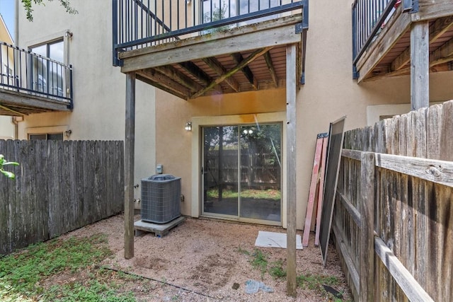 exterior space with central air condition unit, a balcony, and fence