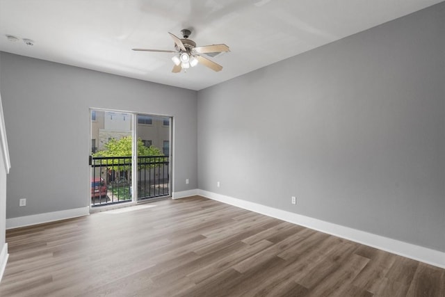 spare room with baseboards, a ceiling fan, and wood finished floors